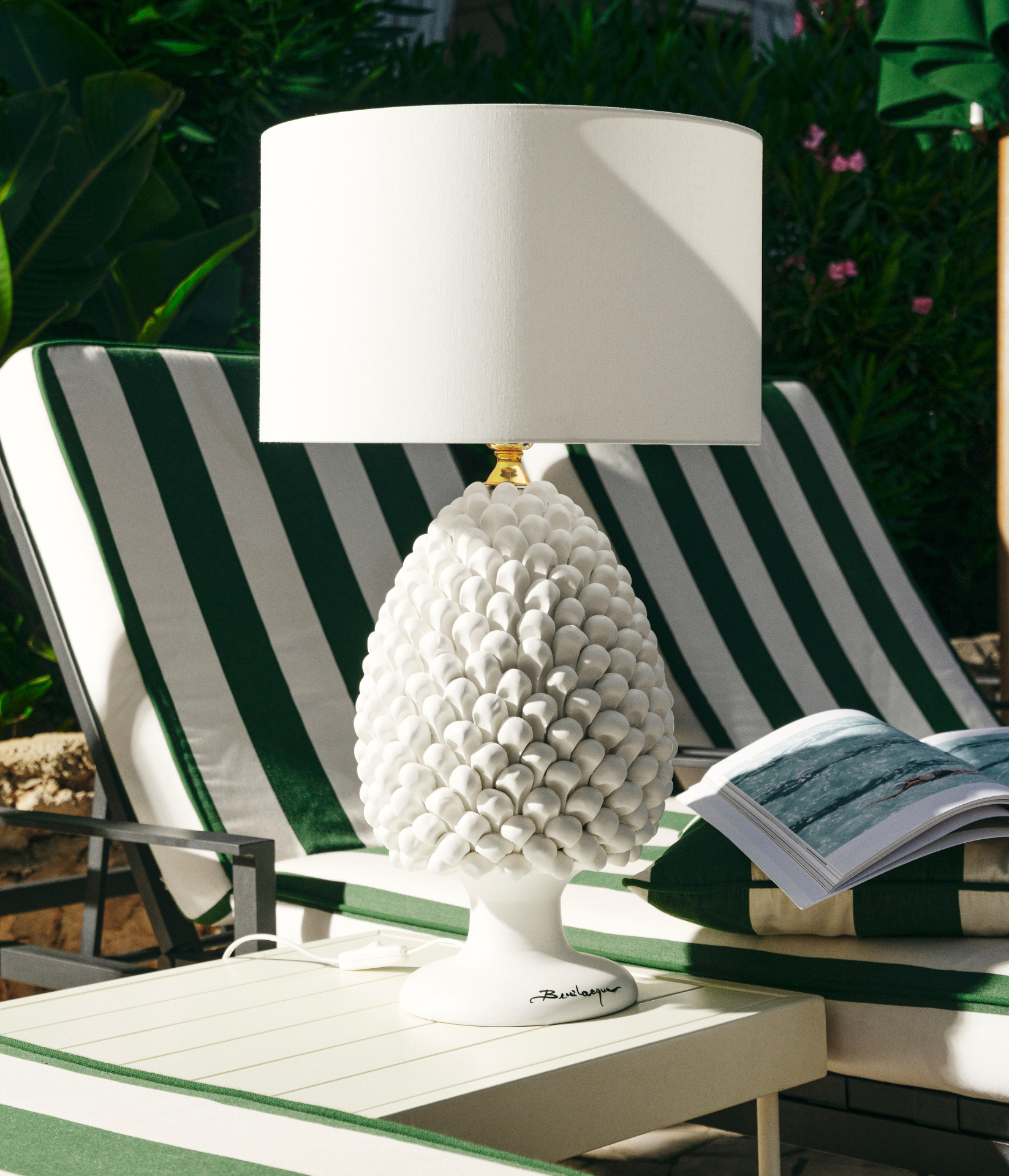 A pineapple lamp sits by a swimming pool