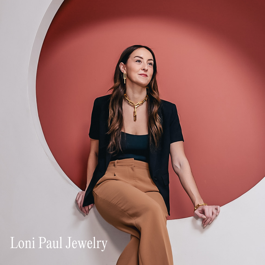 A girl sits in a red circle wearing jewelry