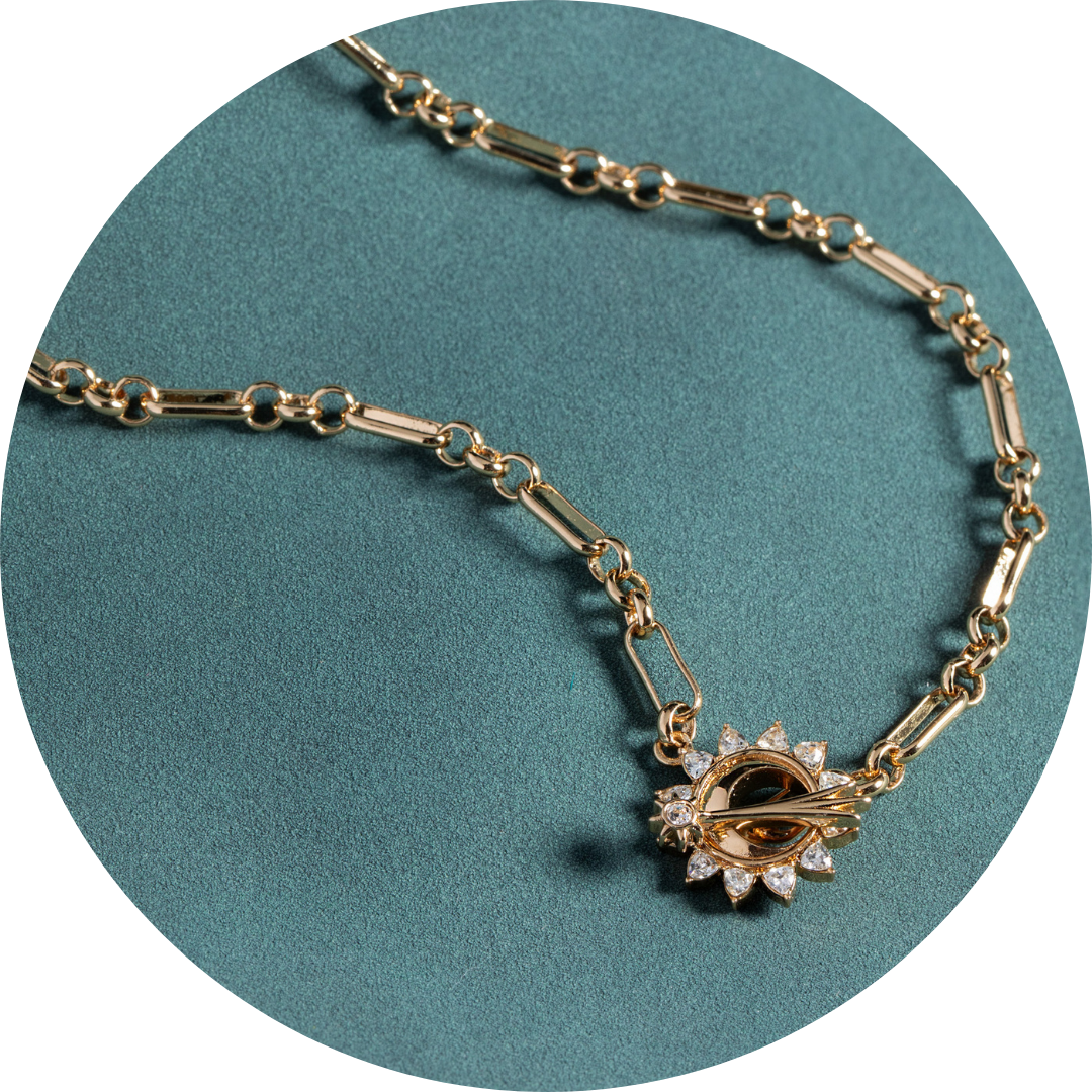 Gold necklace on a teal background