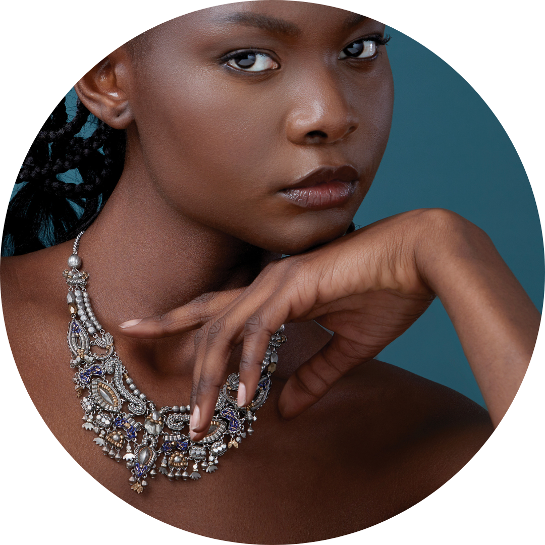 Person with a silver necklace on with a teal background