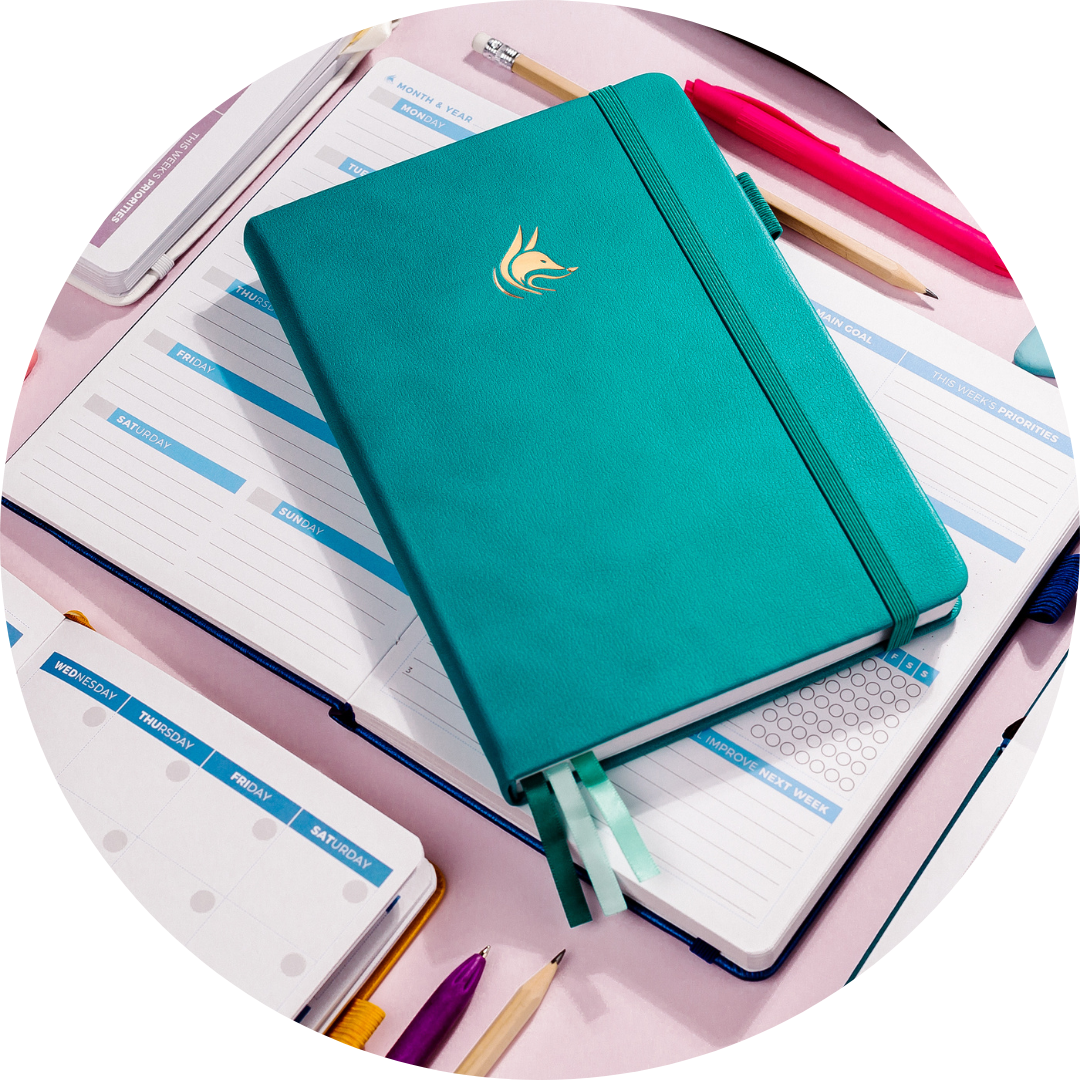 Clever Fox A teal planner on a pile of organizational materials